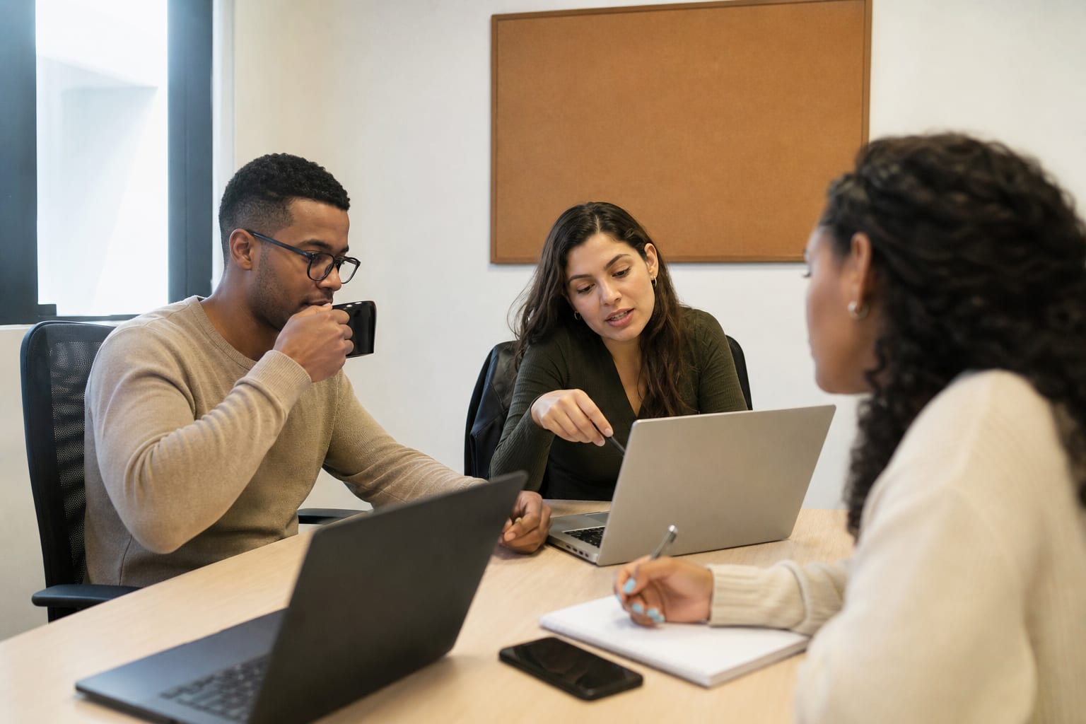 Equipe de marketing de uma rede em reunião de mesa com notebooks abertos